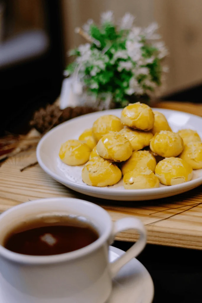 معمول العيد الطازج محشو بالتمر ومزين بالسكر البودرة بعد الخبز